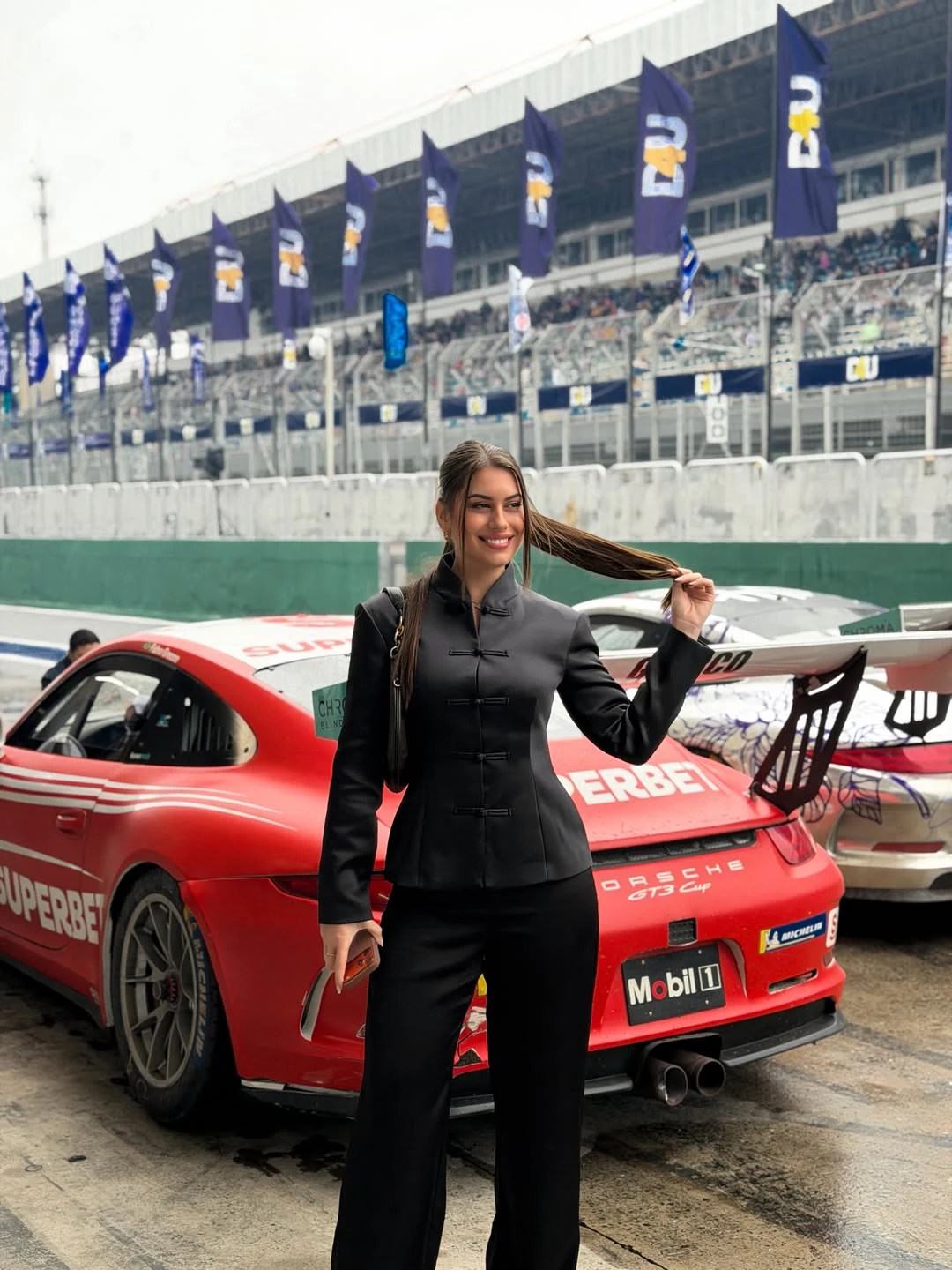 Raissa Dámian em frente a um carro da Porsche Cup